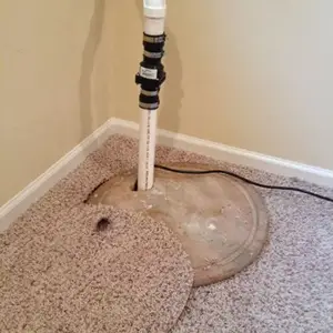 Placing carpeting over a sump pump basin cover will reduce the noise made by the pump. Notice that the check valve is above the floor. Many check valves (not all) also make noise. Photo credit 1-Tom-Plumber