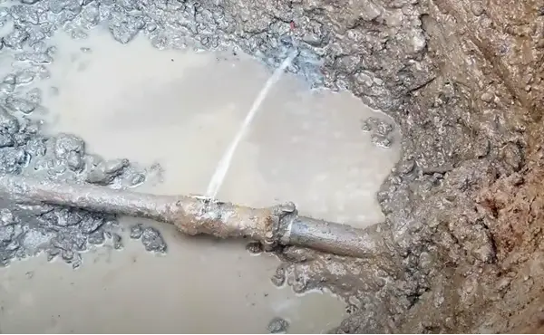 Water spraying out of an underground water pipe. Broken water pipes are the main reason for seeing water coming out of the ground in the yard. Image credit: Fix It All