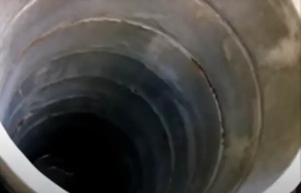The inside of a multi section concrete ring dry well.