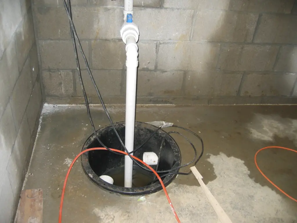 Open sump pump basin in a concrete block basement. Image credit DOE