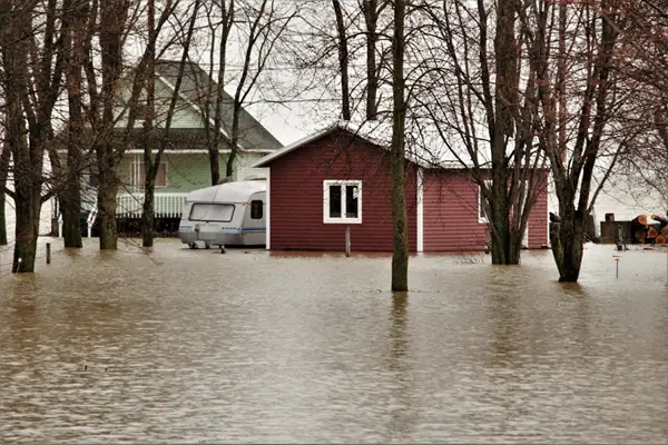 Home, garage and recreational vehicle in flood water.